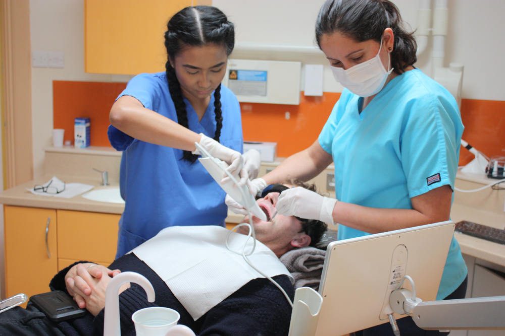 Dental World team taking a digital scan of a patient's teeth with a TRIOS scanner